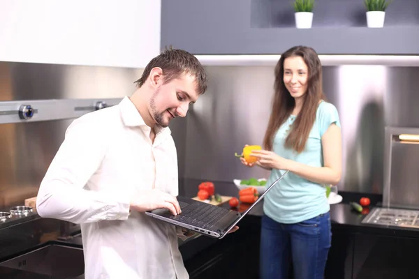 Couple devant ordinateur portable dans la cuisine — Photo