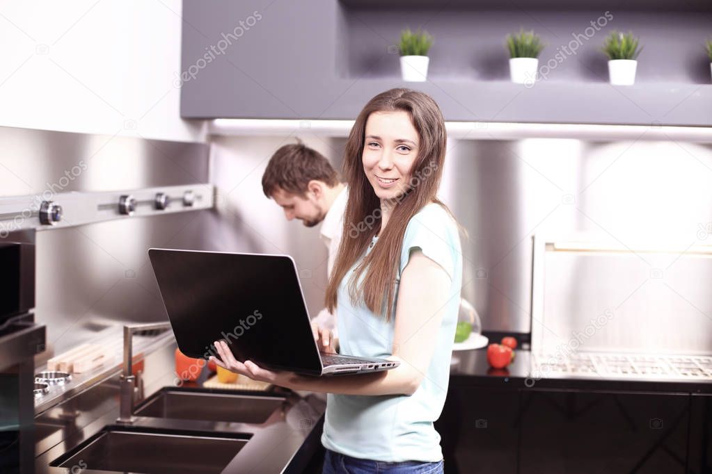 Couple in front laptop computer in the kitchen