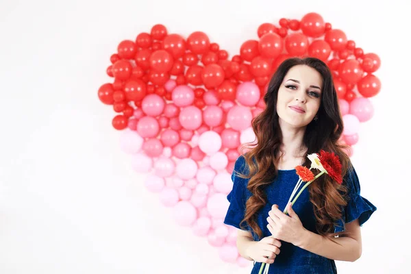 Mujer morena sexy con globos de corazón rojo y flores — Foto de Stock