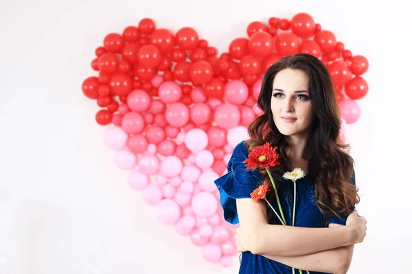 Mujer morena sexy con globos de corazón rojo y flores — Foto de Stock