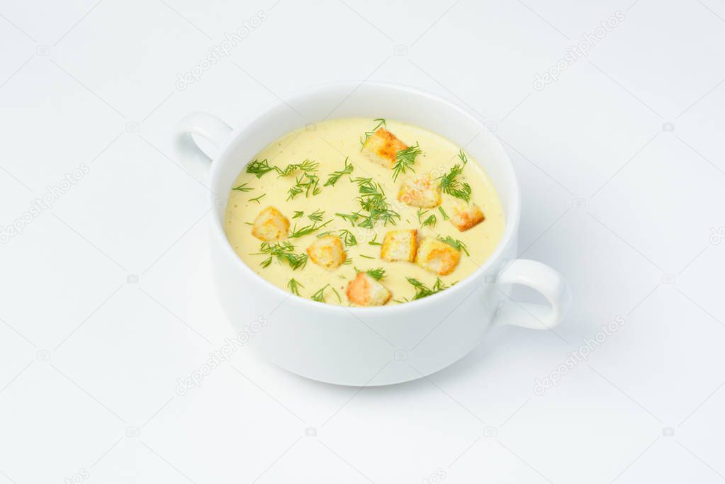 Cheese cream soup with croutons and fresh herbs. White background