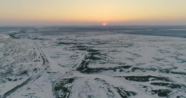 Schneebedeckte Felder bei Sonnenuntergang aus der Vogelperspektive — Stockvideo