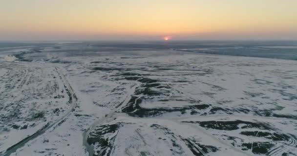Met sneeuw bedekte velden bij zonsondergang vanuit vogelperspectief — Stockvideo