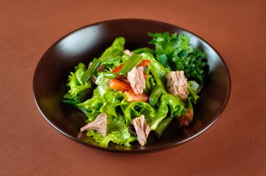 Kahverengi bir masada yeşil fasulyeli salata ve ton balığı.