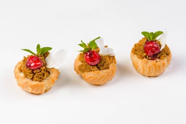 Beyaz arka planda karaciğer ezmesi ve kirazlı ekler.