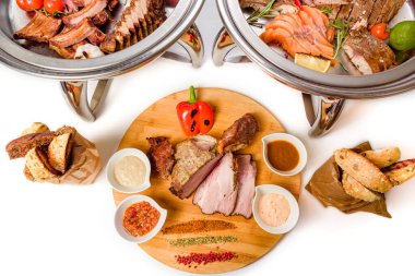 Beyaz arka planda sebzeli ve soslu çeşitli et.