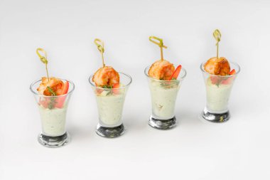 Beyaz arka planda cam yığınında soslu abur cubur karidesi.