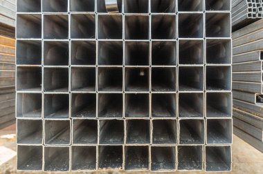 Arka plandaki metal boruları kapatın. Fabrikada yığınla yeni çelik boru var.