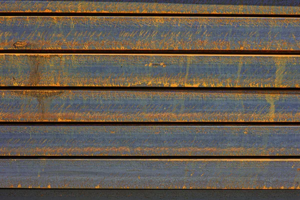 Racks of metal profiles. Metal is stored in an open warehouse. Wet and rusty on the street. Old grunge background made of rusty iron for shooting flatleys on the table