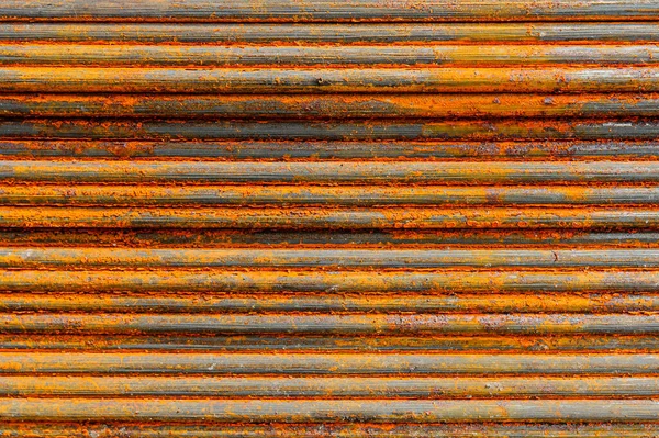 Racks of metal profiles. Metal is stored in an open warehouse. Wet and rusty on the street. Old grunge background made of rusty iron for shooting flatleys on the table