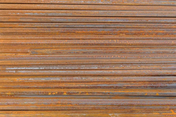 Racks of metal profiles. Metal is stored in an open warehouse. Wet and rusty on the street. Old grunge background made of rusty iron for shooting flatleys on the table