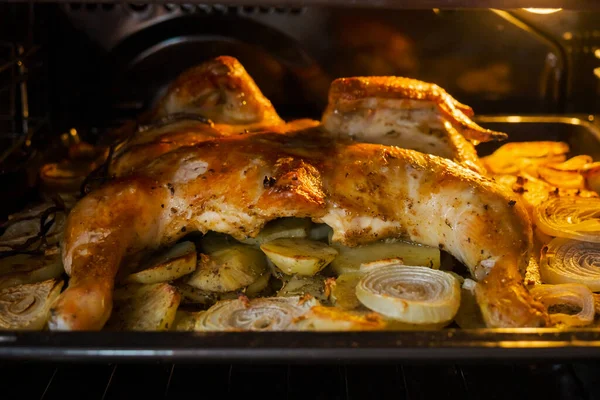 Fried chicken with baked potatoes and onions in the oven — Stock Photo, Image