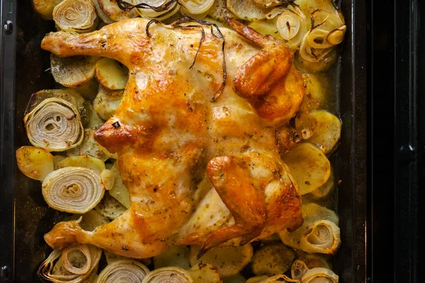 Fried chicken with baked potatoes and onions in the oven. The view from the top — Stock Photo, Image