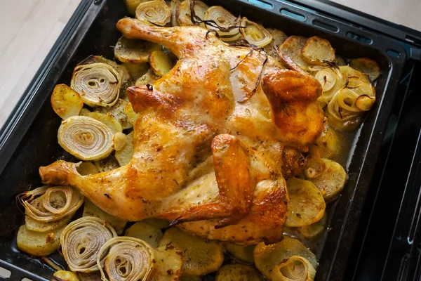 Fried chicken with baked potatoes and onions in the oven. The view from the top — Stock Photo, Image