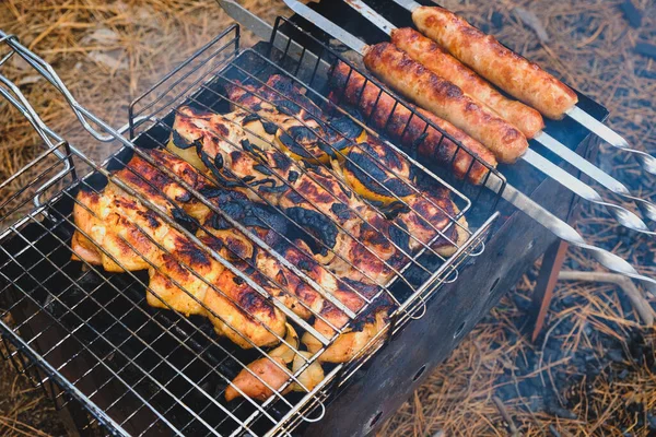 Préparation du shish kebab et des saucisses sur le barbecue extérieur au charbon de bois — Photo