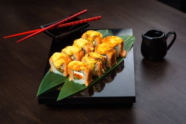 Tahtada sos ve kırmızı çubuklarla fırınlanmış ekmek var.