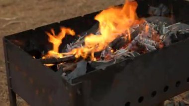 Izgarada ateş yanıyor. Kızarmış şiş kebap için kömür hazırlama