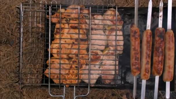 Grill w grillu i kiełbaski są smażone na grillu, zbliżenie. Grill na świeżym powietrzu — Wideo stockowe