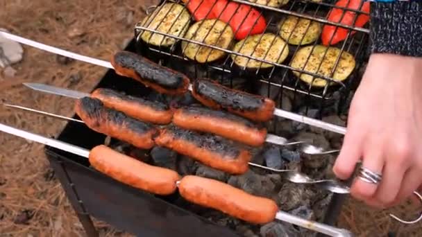 Főtt kolbász a grillen grillezett zöldséggel a természetben. Piknik — Stock videók