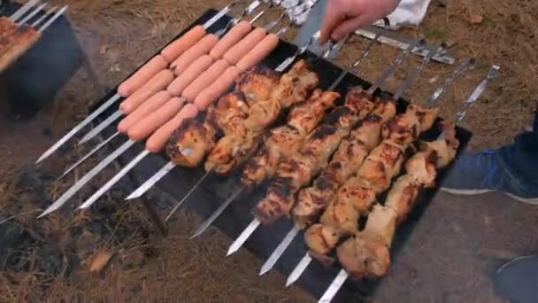 Barbacoa en la parrilla y salchichas se fríen en la parrilla, de cerca. Barbacoa exterior — Vídeos de Stock