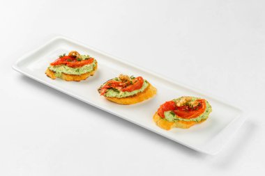 Beyaz arka planda beyaz tabakta aperatif sandviçler. Yemek servisi.
