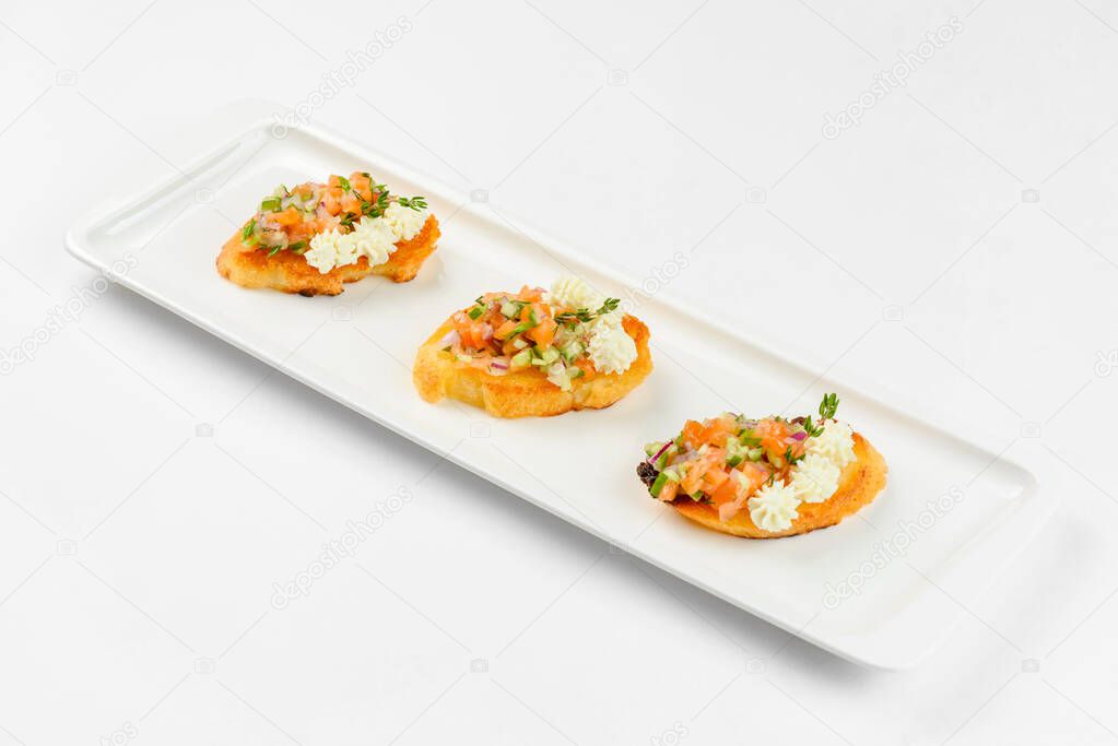 Appetizer sandwiches on a white plate on a white background. Catering service