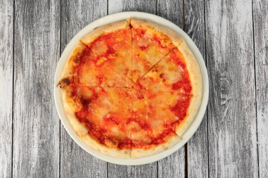 Ahşap arka planda domates soslu pizza. Üst görünüm, yakın çekim