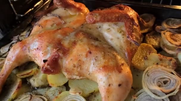 Gefrituurde kip met specerijen en aardappelen op een bakplaat wordt gebakken in de oven. Het bovenste uitzicht, close-up. — Stockvideo