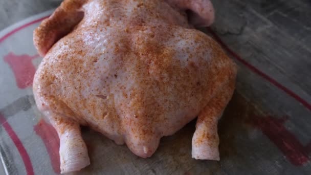 Rå kyckling med kryddor för rostning i ugnen. Ovanifrån, närbild — Stockvideo