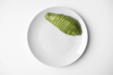 Beyaz arka planda yarım avokado dilimlenmiş, fotokopi alanı da var. Yakın çekim, üst görünüm