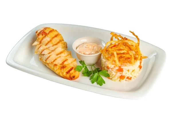 Poitrine de poulet cuite au four avec sauce et riz aux légumes sur une assiette rectangulaire blanche sur fond blanc — Photo