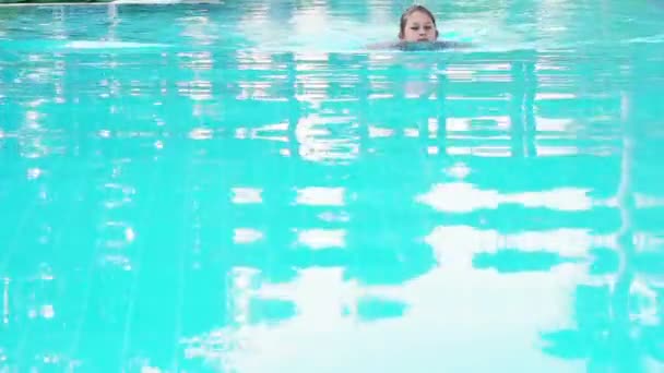 Klein meisje zwemt in het zwembad — Stockvideo