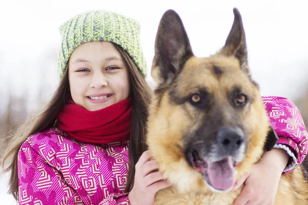 Kind umarmt Hund, Winterspaziergang — Stockfoto