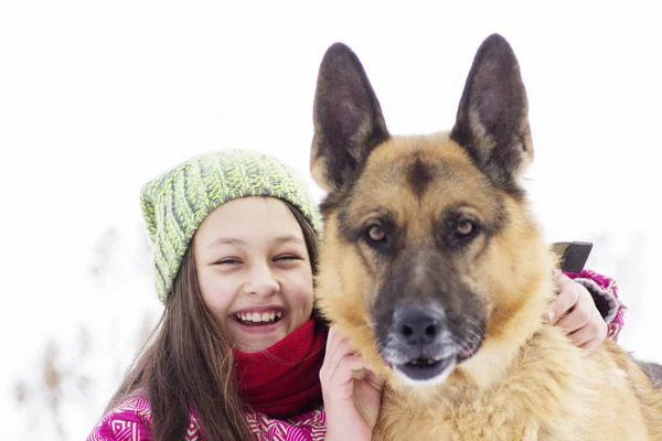 Criança abraçando um cão, passeio de inverno — Fotografia de Stock