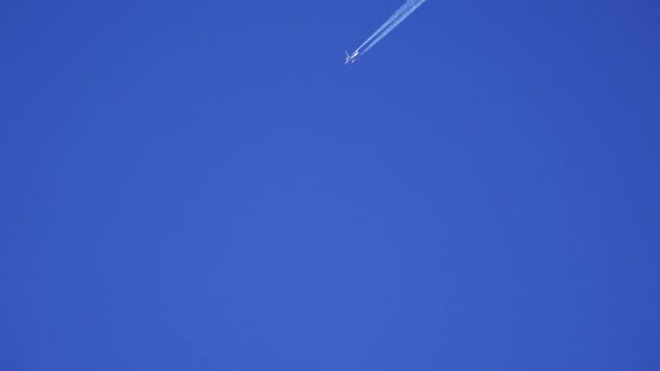 Самолёт оставляет след в небе. 4K . — стоковое видео