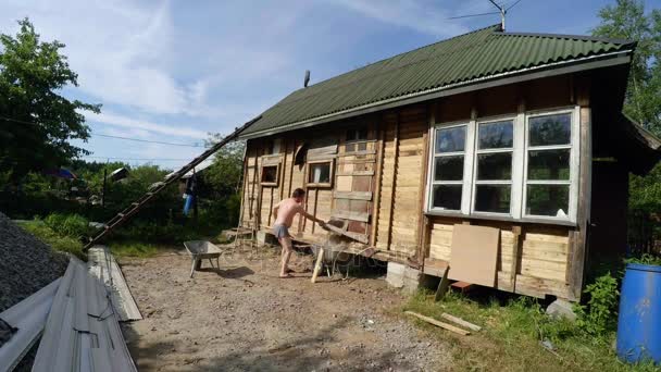 Os trabalhadores desmontam e demolir a velha casa de madeira. 4K . — Vídeo de Stock