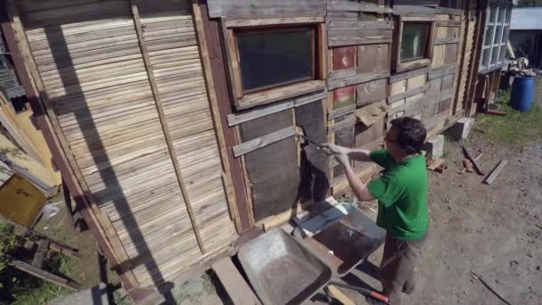 Рабочие демонтируют и сносят старый деревянный дом. 4K . — стоковое видео