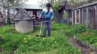 Elektrikli çim biçme makinesi çimenlikteki çimleri biçiyor. 4K