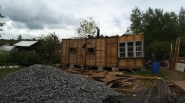 İşçi ortadan kaldırmak ve eski ahşap evi yıkmak. 4k.