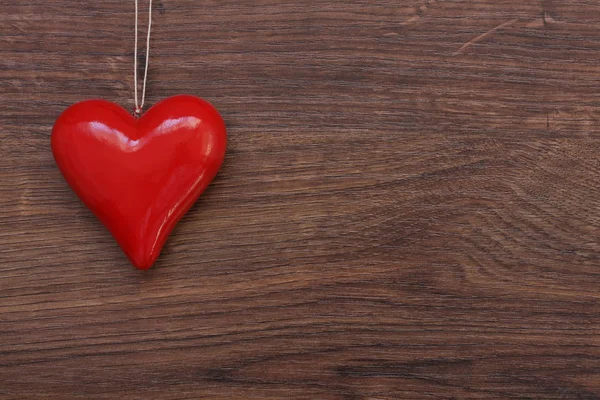 Красива Червона серце висить на рядок над дерев'яними тлі. В. а. — стокове фото