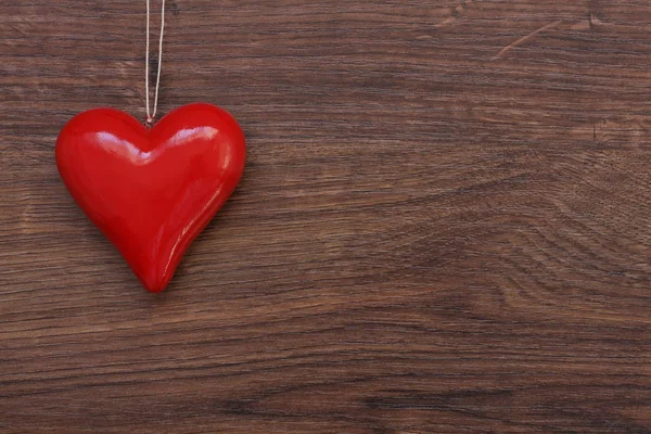 Beau coeur rouge suspendu à une ficelle sur un fond en bois. Va — Photo