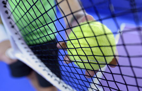 hand holding ball near racket