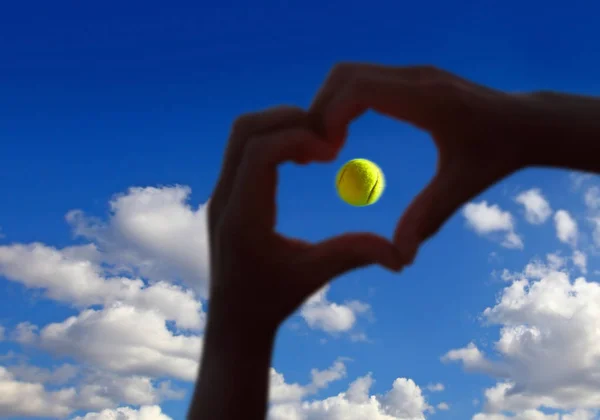 Tennis ball midair with cloudy sky above — Stock Photo, Image