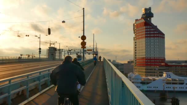 Personas cruzando el puente en bicicletas — Vídeo de stock