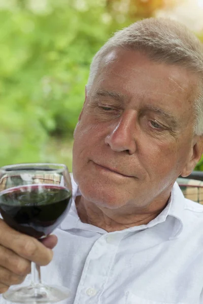 Homem bonito maduro com um copo de vinho — Fotografia de Stock