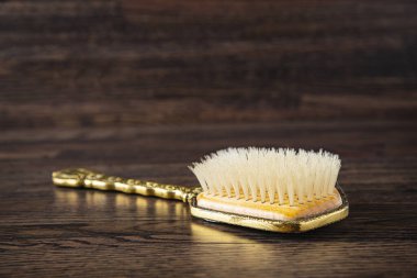 Eski moda saç fırçası, koyu bir ahşap arka plana karşı.