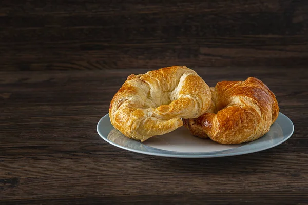 Dois Croissant Estaca Cima Outro Uma Placa Jantes Azul Contra — Fotografia de Stock