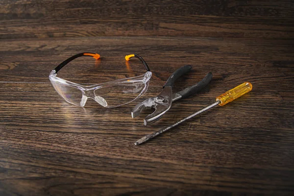 Protective Glasses Plier Screwdrive Dark Wood Background — Stock Photo, Image
