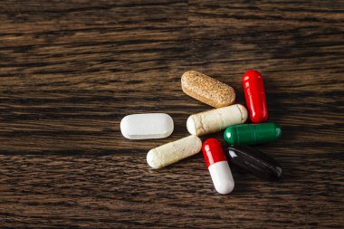 Hap, kapsül, ahşap arka planda doğal takviye tableti.