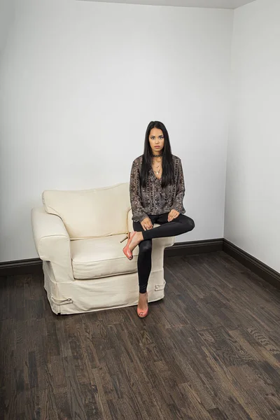 Genç Bir Kadın Beyaz Koltuğun Kolunda Oturuyor Bir Odanın Köşesinde — Stok fotoğraf